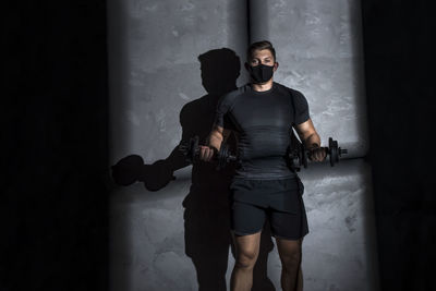 Portrait of man wearing mask while exercising at gym