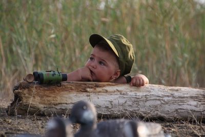 Baby boy wearing cap while sitting outdoors