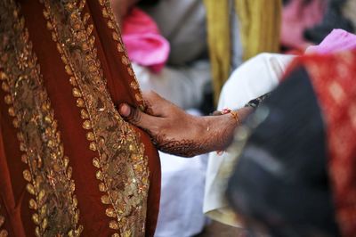 Midsection of groom holding textile 