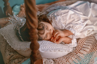 High angle view of cute girl sleeping on bed at home