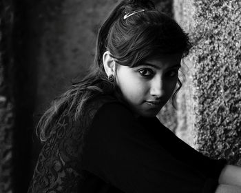 Portrait of beautiful woman against wall