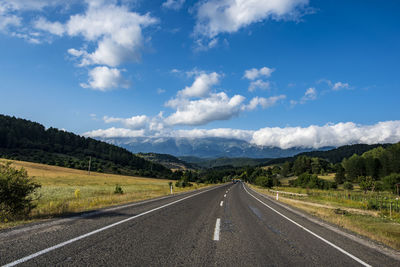 Empty road along countryside landscape