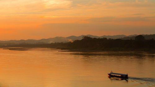 Scenic view of lake against orange sky