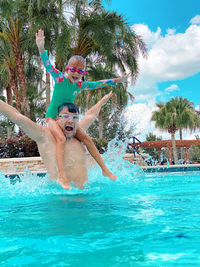 A girl with her dad in the swimming pool