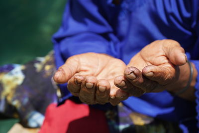 Close-up of man holding hands against blurred background