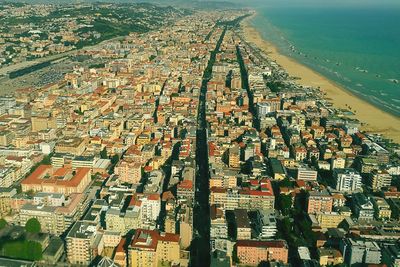 High angle view of cityscape by sea against sky