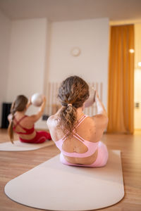 Side view of young woman sitting on table