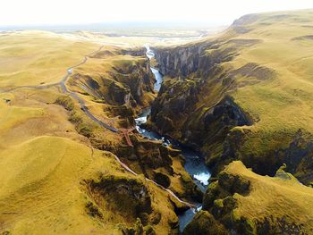 Aerial view of river amidst cliffs against sky