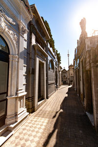 Footpath amidst buildings against sky