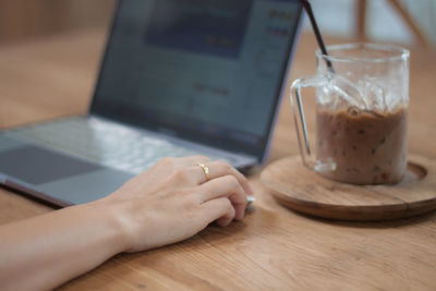 Midsection of man using smart phone on table