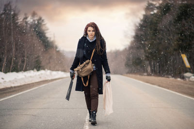 Portrait of young woman walking on snow
