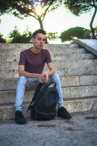 Portrait of young man sitting on staircase
