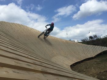 Man riding bicycle on bikepark against sky