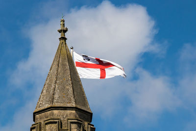 Low angle view of flag on building against sky