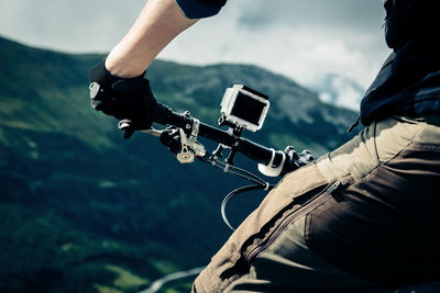 Midsection of man holding bicycle handlebar