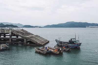 Boats moored in sea against sky