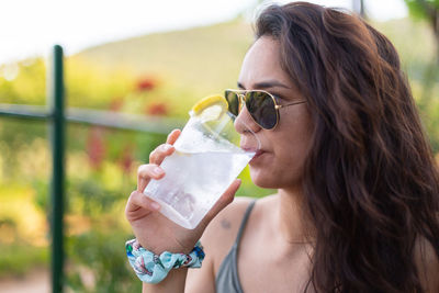 Young woman drinking gin and tonic at a party