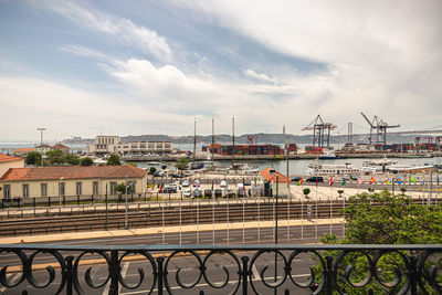 Bridge over river by buildings in city against sky