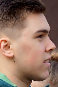Profile view of young man standing outdoors