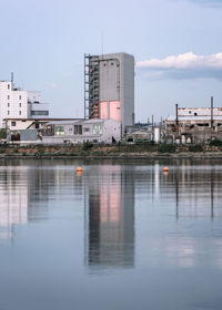 Reflection of buildings in river against sky