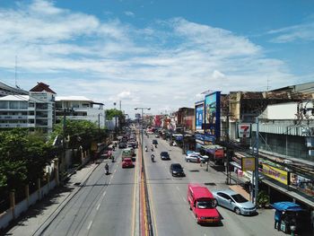 Traffic on city street by buildings against sky