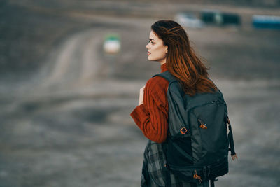 Side view of young woman looking away outdoors