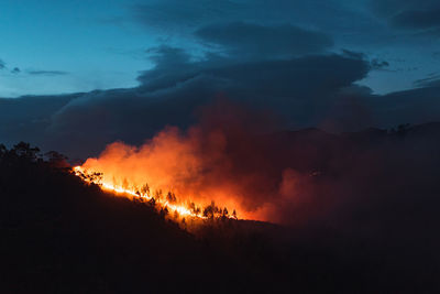 Countryside forest with cloudy sky covered by fire smoke during the evening