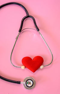 High angle view of heart shape on pink over red background