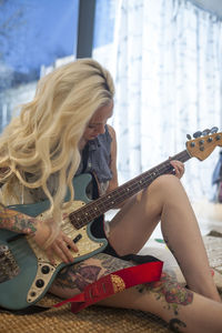 Beautiful young woman playing an electric guitar