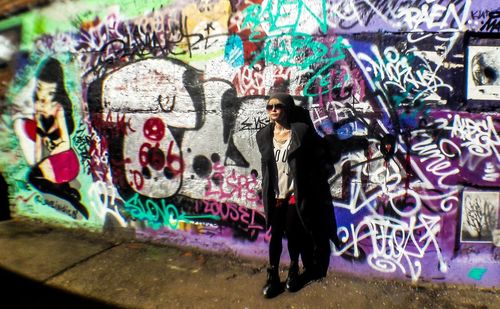 Full length of woman standing on graffiti