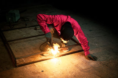 Welder used grinding stone on steel in factory with sparks, welding process at the industrial work