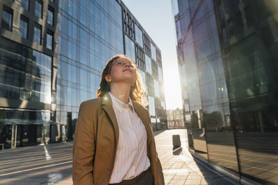 Thoughtful businesswoman looking up on sunny day