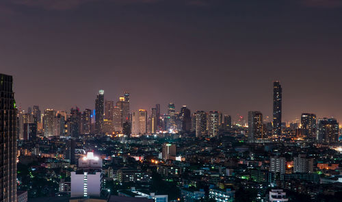 Illuminated cityscape against sky at night