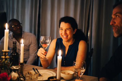 Happy woman enjoying dinner party with friends at home