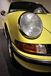 Close-up of yellow car on street