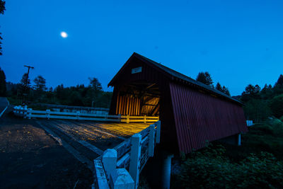 Covered footbridge against clear sky at dusk