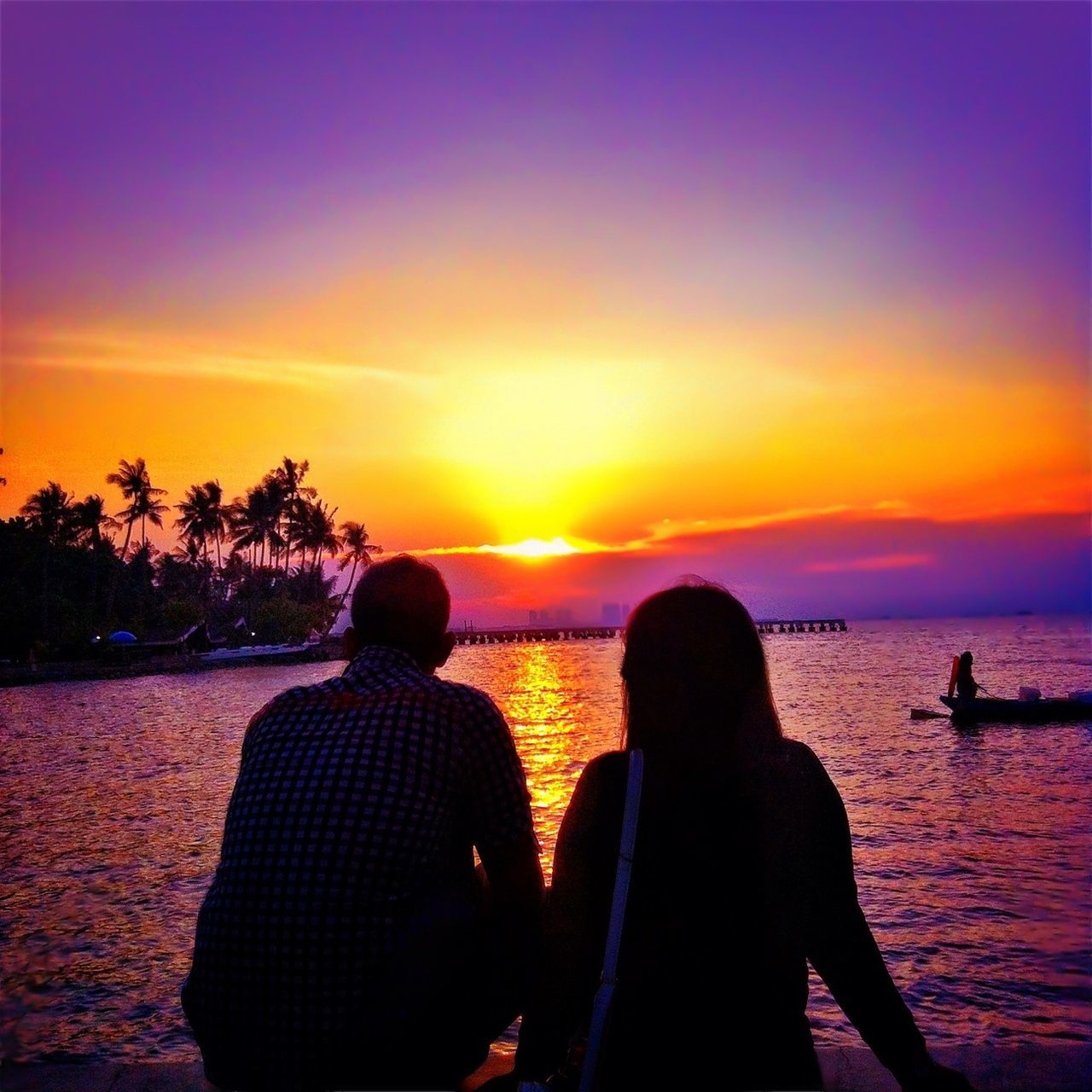 sunset, water, silhouette, sea, lifestyles, sky, leisure activity, orange color, togetherness, beauty in nature, horizon over water, scenics, person, beach, sun, tranquil scene, men, tranquility