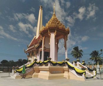 Traditional temple by building against sky