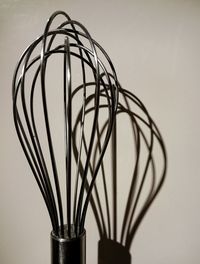 Close-up of wire whisk against wall