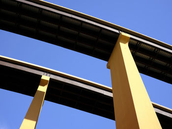 Low angle view of bridge against clear blue sky