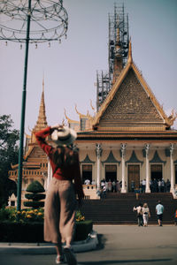 Rear view of woman standing against built structures