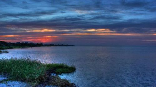 Scenic view of sea against cloudy sky