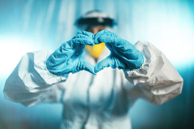 Doctor makes a heart with his hands inside covid ward. coronavirus hospital.