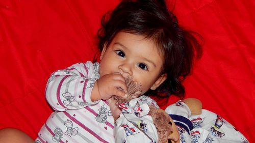 High angle portrait of cute baby girl lying at home