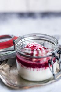 Jar of homemade frozen yogurt with raspberry topping