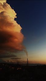 Silhouette buildings against dramatic sky during sunset