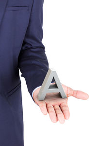 Midsection of man holding mobile phone against white background