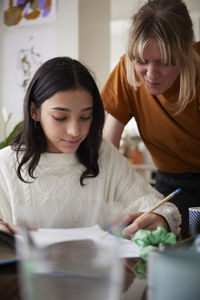 Mother assisting to girl doing homework