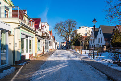 Street amidst buildings against blue sky