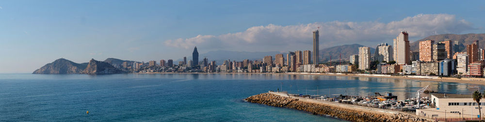 Panoramic view of sea and city buildings against sky